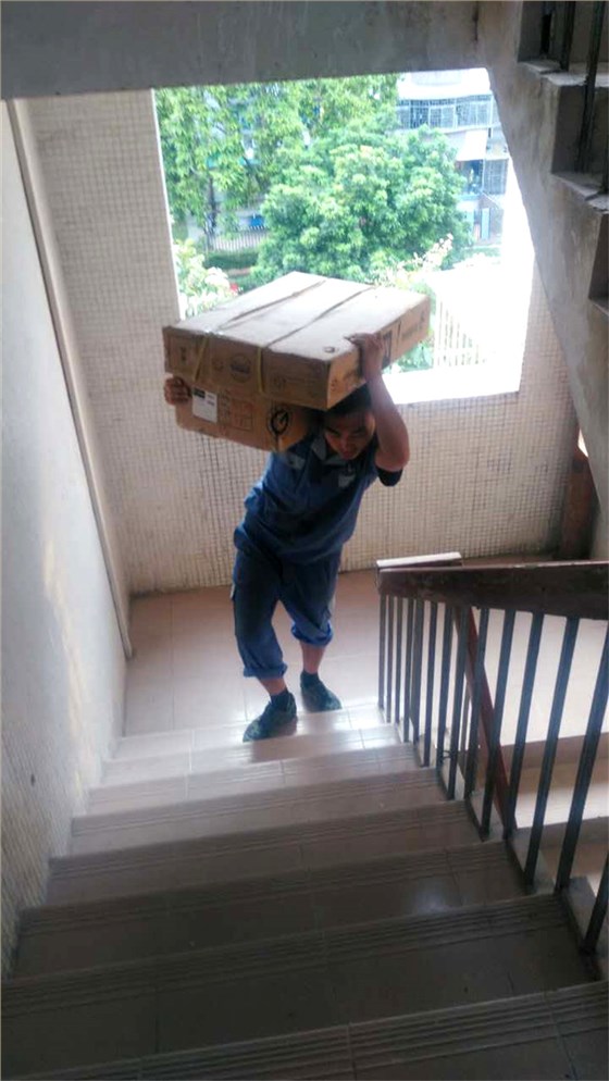 左右手家具安裝師傅扛著(zhù)家具材料上樓梯