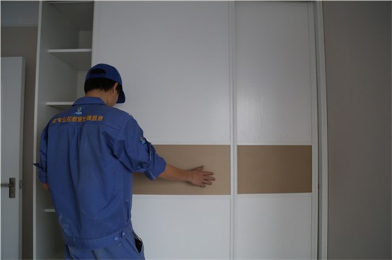 家具安裝工正在現場(chǎng)進(jìn)行實(shí)木衣柜維修工作