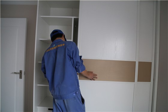 家具安裝工正在調整衣柜門(mén)