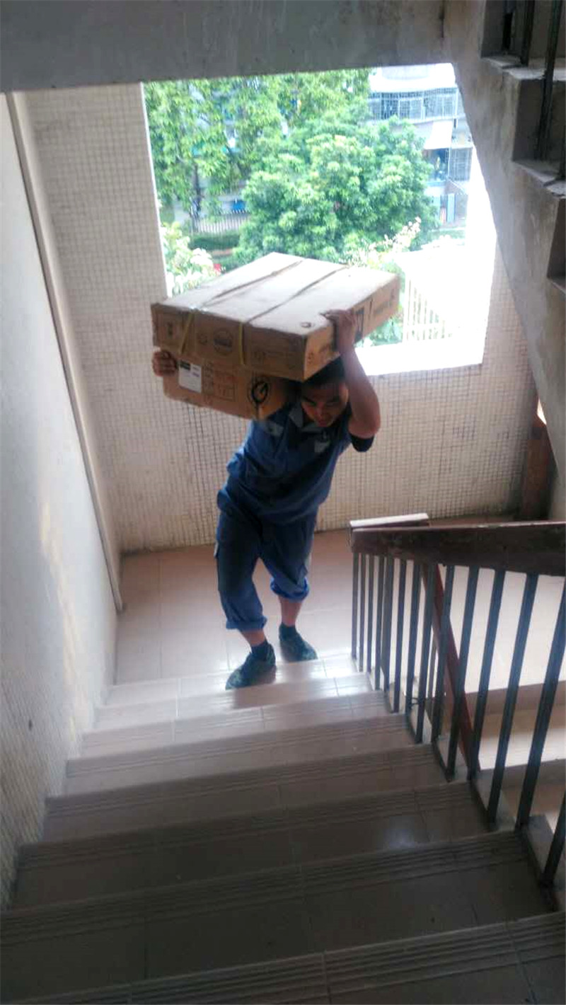 左右手家具安裝師傅扛著(zhù)家具材料上樓梯