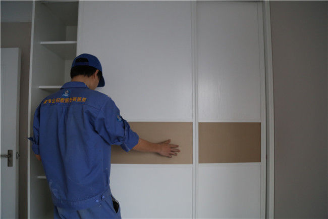 家具安裝工正在現場(chǎng)進(jìn)行實(shí)木衣柜維修工作